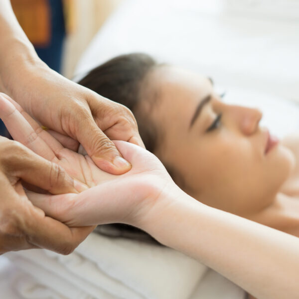 Young woman receiving hand massage in spa.